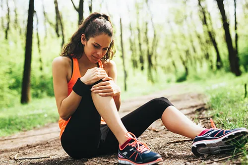 Woman runner holding painful knee