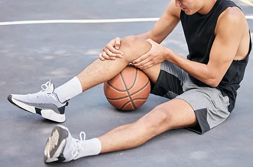 basketball player holding painful knee
